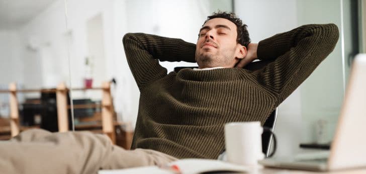 person sitting relaxed with hands behind head